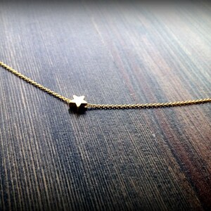 May include: A delicate gold chain necklace with a small star pendant.