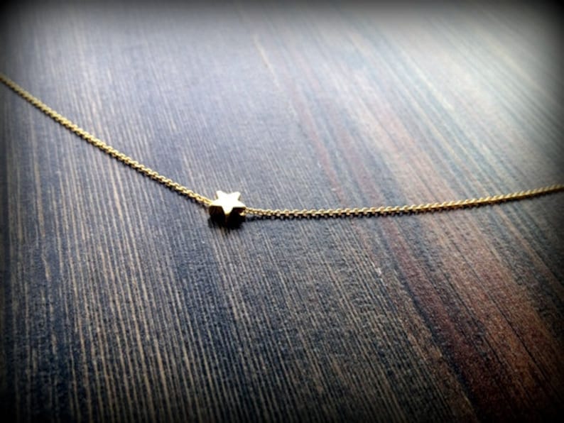 May include: A delicate gold chain necklace with a small star pendant.