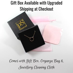 May include: A gold necklace with a small circle pendant comes in a black gift box with a pink organza bag and a cleaning cloth. The box has the logo "PS PINK SLATE" on it.
