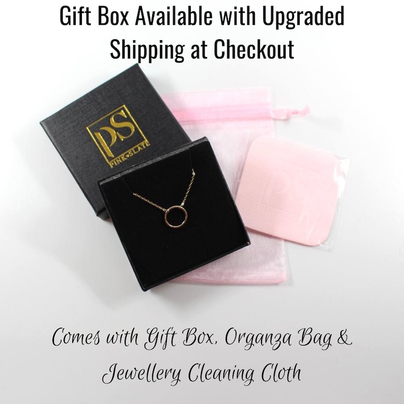 May include: A gold necklace with a small circle pendant comes in a black gift box with a pink organza bag and a cleaning cloth. The box has the logo "PS PINK SLATE" on it.