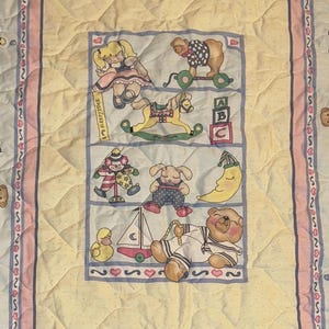 May include: A white ceramic mug with a black handle and the text "But First, Coffee" in a bold, black font. The mug is set against a blurred background, suggesting a cozy setting.