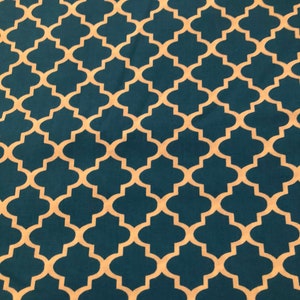May include: A teal fabric with a repeating quatrefoil pattern in a cream color. The design is symmetrical and covers the entire surface, creating a visually appealing texture. This fabric is suitable for various craft projects.