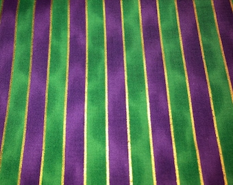 May include: Fabric with vertical stripes in green, purple, and gold. The stripes are evenly spaced and run from top to bottom. The fabric has a slight sheen, and the colors are vibrant.