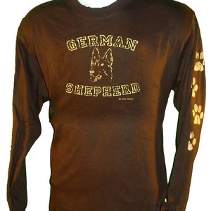 May include: Brown long-sleeve t-shirt with a gold graphic of a German Shepherd dog and the text "GERMAN SHEPHERD" with paw prints on the sleeves.