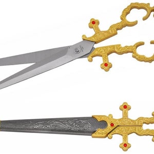 May include: A pair of ornate gold scissors with red accents and a silver blade. The scissors are closed and have a decorative design. The second image shows a matching dagger with a silver blade and gold handle.