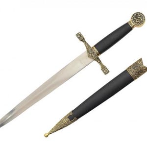 May include: A medieval-style dagger with a silver blade and a black handle. The hilt and pommel are gold-colored with ornate designs. The dagger is accompanied by a black sheath with gold-colored accents.