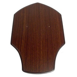 May include: A dark brown wooden plaque with a shield shape. The plaque has two small holes near the top.