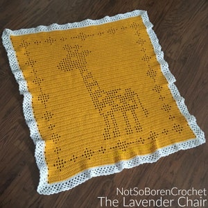 Puede incluir: Una manta de bebé de crochet amarilla con un borde de crochet blanco. La manta presenta un diseño de jirafa.