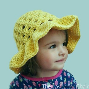 May include: A yellow crocheted sun hat with a wide brim. The hat is made with a delicate open stitch pattern and has a scalloped edge.