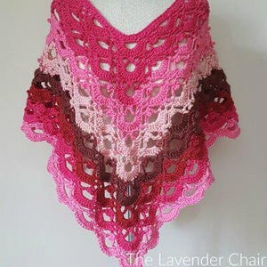 May include: A crocheted shawl in shades of pink, red, and brown. The shawl is triangular in shape and has a delicate lace pattern.