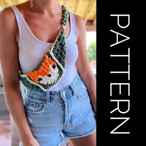 Könnte beinhalten: Eine grüne, weiße und orangefarbene gehäkelte Umhängetasche in Form eines Fuchses. Die Tasche wird von einer Person über einem weißen Tanktop und einer blauen Jeans-Shorts getragen.