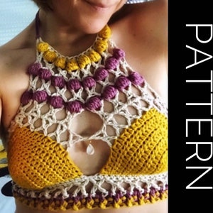May include: A crocheted halter top with a geometric design in yellow, white, and purple. The top has a cutout in the front and is decorated with small crocheted balls.