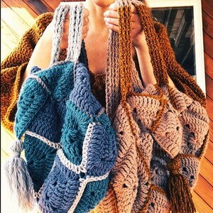 May include: Two crocheted tote bags with tassels. One bag is teal, blue, and white. The other bag is brown, beige, and gold.