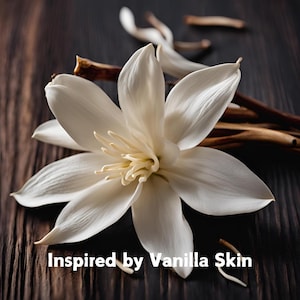 May include: A single white flower with a yellow center, lying on a dark brown wooden surface. The flower is surrounded by dried vanilla bean pods. The text "Inspired by Vanilla Skin" is visible at the bottom of the image.