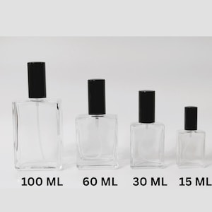 Może przedstawiać: Cztery przezroczyste szklane butelki perfum z czarnymi zakrętkami, oznaczone 100 ml, 60 ml, 30 ml i 15 ml. Butelki są prostokątne i mają atomizer. Tło jest białe.