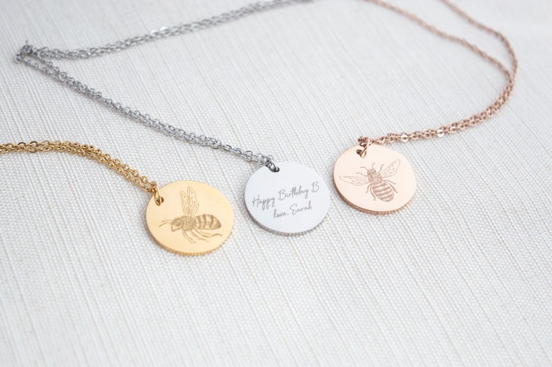 a disc necklace engraved with a bee, available in gold, silver and rose gold
