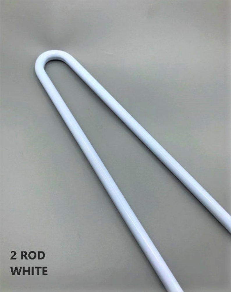 Puede incluir: Dos varillas de metal blanco, cada una doblada en forma de U. Las varillas se utilizan para sostener cortinas u otras cortinas.
