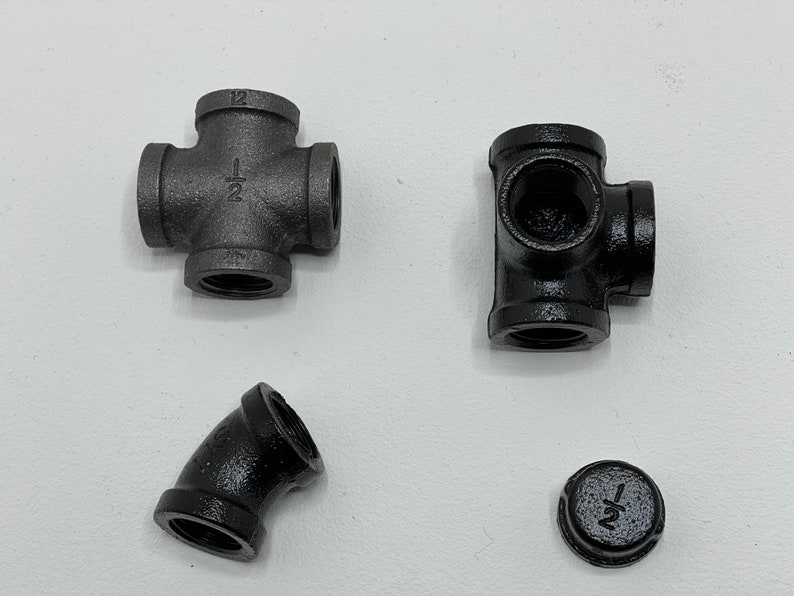 May include: Four black iron pipe fittings, including a cross, a tee, an elbow, and a cap. All fittings are 1/2 inch.