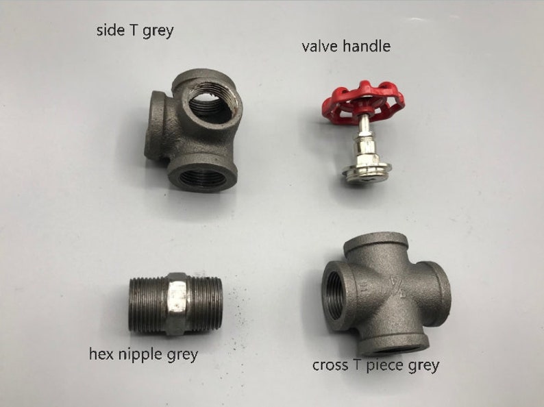 May include: Four plumbing fittings in grey metal, including a side T, a cross T, a hex nipple, and a valve handle with a red knob.