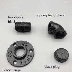 May include: A set of black iron pipe fittings, including a hex nipple, 90 degree bend, flange, and plug. The flange is marked with the numbers 1/2 and 1971.