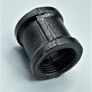 May include: Black iron pipe fitting with threaded ends. The fitting is designed to connect two pipes together.