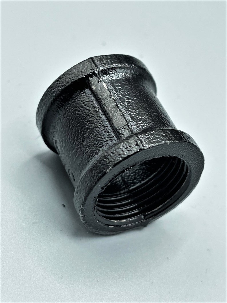 May include: Black iron pipe fitting with threaded ends. The fitting is designed to connect two pipes together.