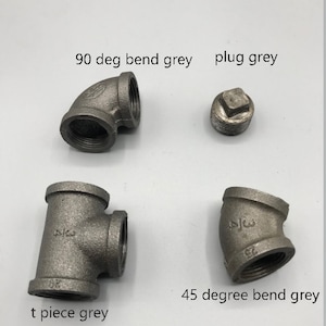 May include: Four grey metal pipe fittings: a 90 degree bend, a 45 degree bend, a t-piece, and a plug.