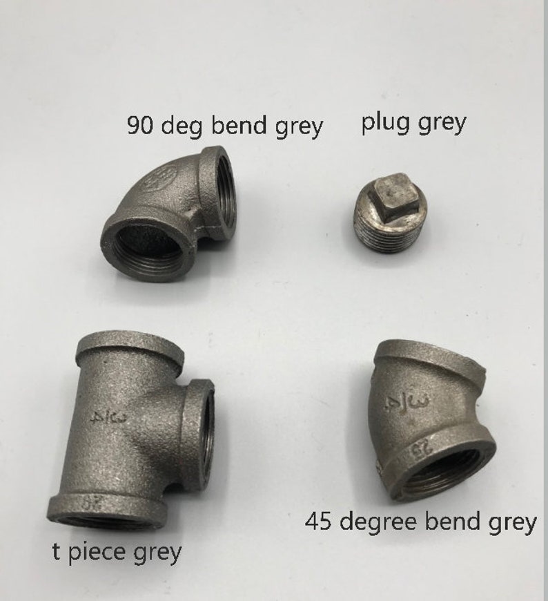 May include: Four grey metal pipe fittings: a 90 degree bend, a 45 degree bend, a t-piece, and a plug.