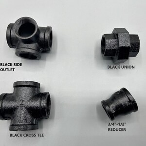 May include: Four black iron pipe fittings: a side outlet, a union, a cross tee, and a 3/4-inch to 1/2-inch reducer.