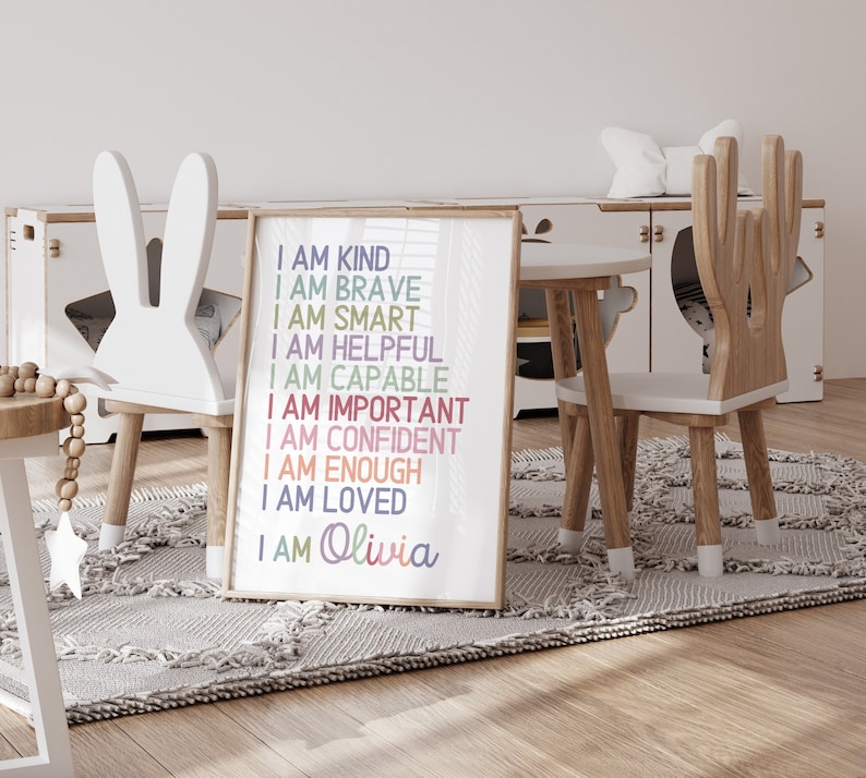May include: A framed print with the text "I am kind, I am brave, I am smart, I am helpful, I am capable, I am important, I am confident, I am enough, I am loved, I am Olivia" in colorful text on a white background.
