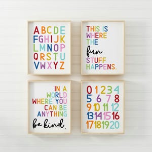 May include: Four framed prints with colourful text on a white background. The prints feature the alphabet, numbers 0-20, the phrase "This is where the fun stuff happens", and the phrase "In a world where you can be anything, be kind."