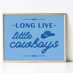 May include: A blue and gold framed print with the text "Long Live Little Cowboys" in blue script. A blue cowboy hat with a star is above the word "cowboys".