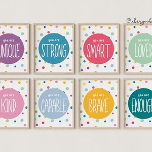 May include: Eight framed prints with colourful polka dot backgrounds and white circles containing positive affirmations. The text on the prints reads: "You are Unique", "You are Strong", "You are Smart", "You are Loved", "You are Kind", "You are Capable", "You are Brave", and "You are Enough".