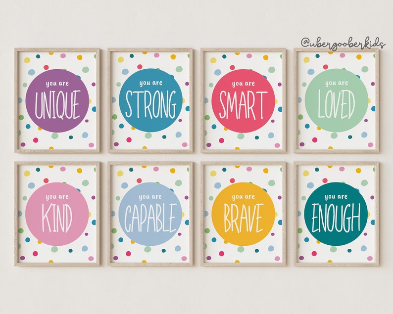 May include: Eight framed prints with colourful polka dot backgrounds and white circles containing positive affirmations. The text on the prints reads: "You are Unique", "You are Strong", "You are Smart", "You are Loved", "You are Kind", "You are Capable", "You are Brave", and "You are Enough".