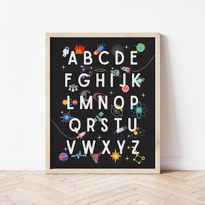 May include: A black and white alphabet poster with a space theme. The letters are white and surrounded by colorful planets, stars, rockets, and other space-related imagery.
