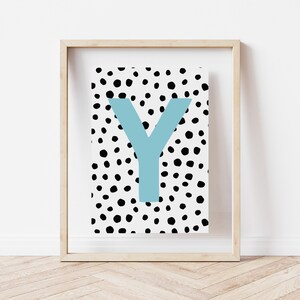 May include: A framed print with a white background and black polka dots. The letter "Y" is in a light blue colour and is centred on the print.