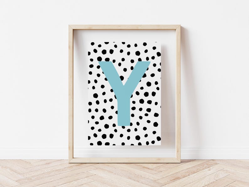 May include: A framed print with a white background and black polka dots. The letter "Y" is in a light blue colour and is centred on the print.