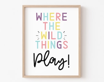 May include: A framed print with the text "WHERE THE WILD THINGS Play!" in colorful letters. The words "WHERE" and "THINGS" are in purple, "THE" is in yellow, "WILD" is in light blue, and "Play!" is in black.
