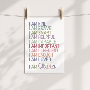 May include: A printable wall art design with the text "I am kind, I am brave, I am smart, I am helpful, I am capable, I am important, I am confident, I am enough, I am loved, I am Olivia" in various colors.