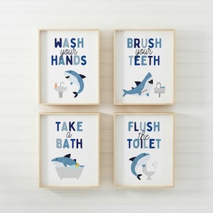 May include: Four framed prints with blue and white shark illustrations and bathroom-related text. The prints read "Wash your hands", "Brush your teeth", "Take a bath", and "Flush the toilet".
