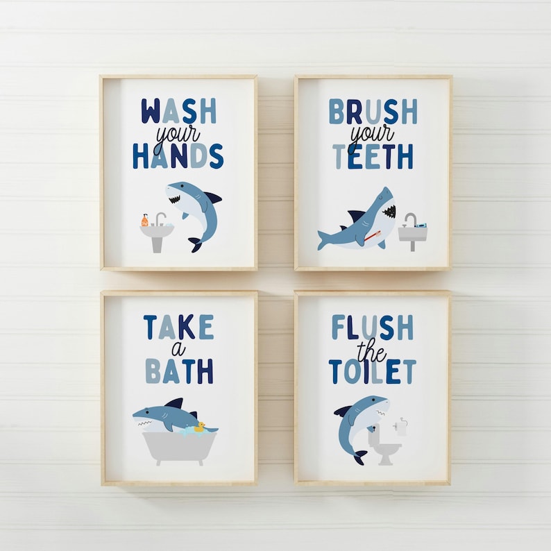 May include: Four framed prints with blue and white shark illustrations and bathroom-related text. The prints read "Wash your hands", "Brush your teeth", "Take a bath", and "Flush the toilet".
