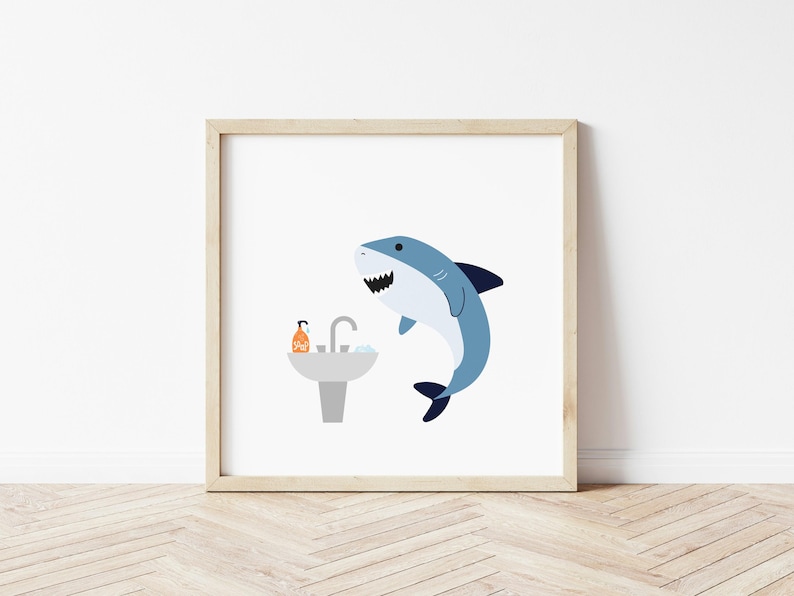 May include: A framed print of a cartoon shark with a blue and gray body, looking at a white sink with a blue faucet and a bottle of orange soap. The shark is in a bathroom setting.