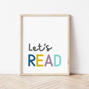 Puede incluir: Una impresi&oacute;n enmarcada con el texto "Let's READ" en letras de colores. Las letras son en tonos de azul, amarillo, morado y turquesa.