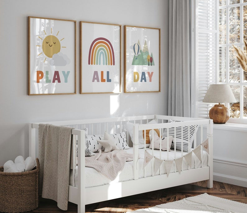 Puede incluir: Tres impresiones enmarcadas con ilustraciones y texto coloridos. La primera impresi&oacute;n presenta un sol amarillo con una cara sonriente y el texto "PLAY". La segunda impresi&oacute;n presenta un arco&iacute;ris con el texto "ALL". La tercera impresi&oacute;n presenta una cordillera con un globo aerost&aacute;tico y el texto "DAY".