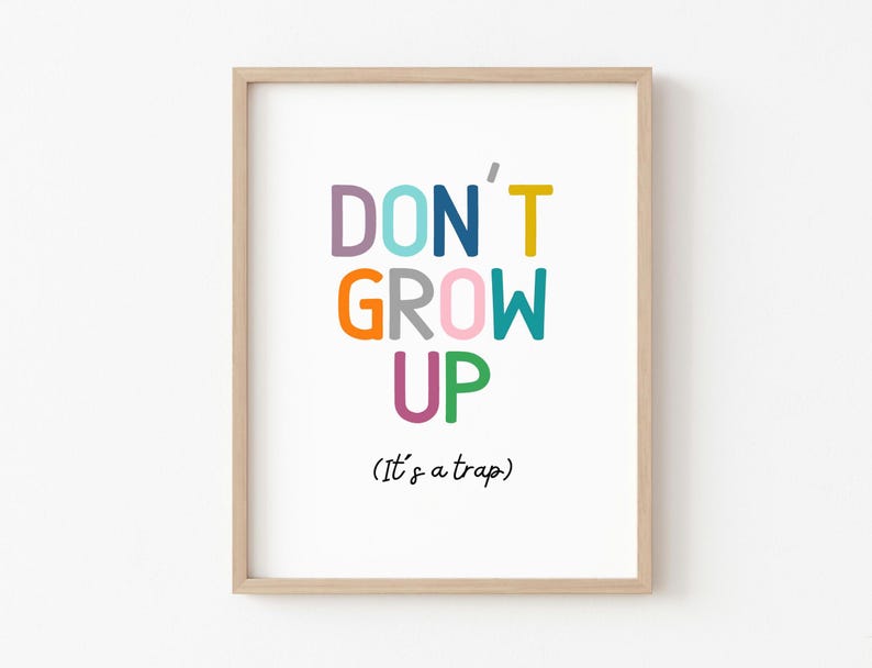 May include: A framed print with the text "DON'T GROW UP (It's a trap)" in colorful letters. The letters are in different colors, including pink, orange, blue, green, and purple.