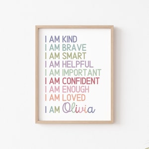 May include: A framed print with the text "I AM KIND, I AM BRAVE, I AM SMART, I AM HELPFUL, I AM IMPORTANT, I AM CONFIDENT, I AM ENOUGH, I AM LOVED, I AM Olivia" in various colors.