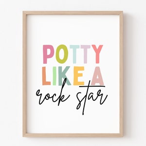 May include: A framed print with the text "POTTY LIKE A rock star" in colorful letters. The letters are in different colors, including pink, yellow, green, and blue.