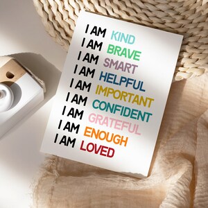 May include: A white card with the text "I AM" followed by a list of positive affirmations in different colors: kind, brave, smart, helpful, important, confident, grateful, enough, and loved.