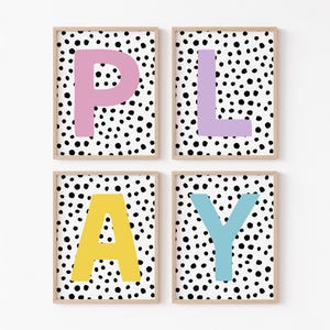 May include: Four framed prints with a black and white polka dot background and a single letter in a bright colour on each print. The letters spell out the word "PLAY" with pink "P", purple "L", yellow "A", and blue "Y".