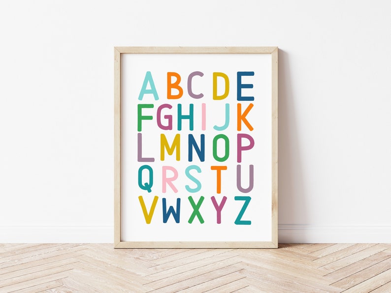 Puede incluir: Una impresi&oacute;n de alfabeto enmarcada con letras coloridas sobre un fondo blanco. Las letras est&aacute;n en una fuente en negrita y juguetona. El marco es de madera clara.